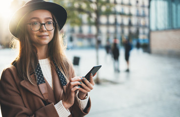 Traveler woman holding mobile phone. Close up technology smartphone online connect. Girl tourist in glasses using gadget cellphone in sun flare city. Digital internet lifestyle mockup