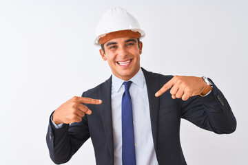 Young handsome architect man wearing suit and helmet over isolated white background looking confident with smile on face, pointing oneself with fingers proud and happy.