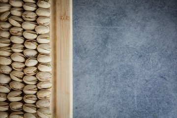 Pistachios nuts on the wood board top view