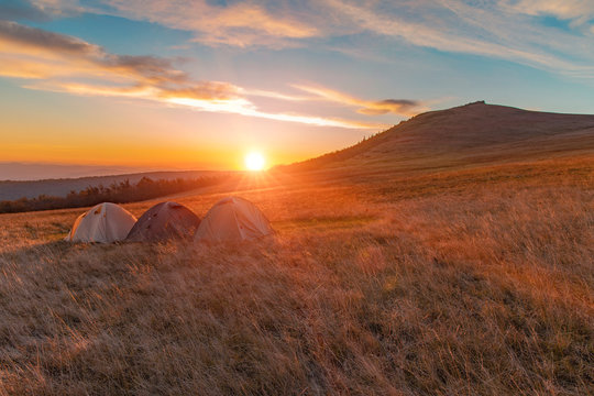 majestic sun rise orange light and rays in picturesque gorgeous Ukrainian Carpathian mountain highland scenery landscape environment camp of three tents, travel life style concept wallpaper picture 