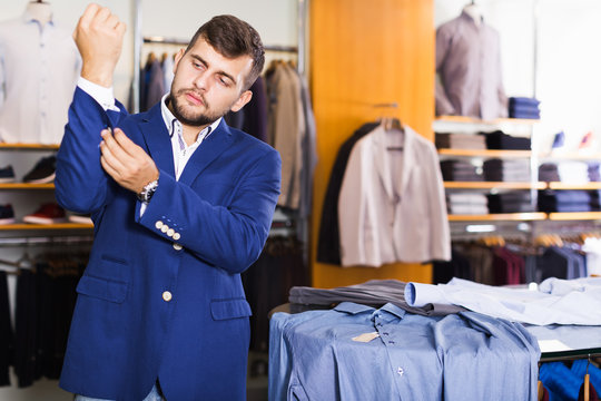 Active male customer choosing jacket