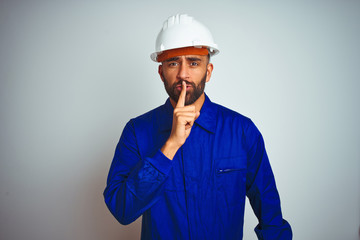Handsome indian worker man wearing uniform and helmet over isolated white background asking to be...