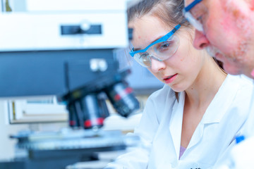 Laboratory assistant uses a polarizing microscope in a microbiological laboratory