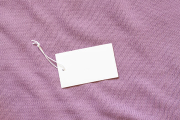 Price tag, blank brand label on pink color knitting clothes