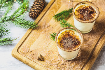 Eggnog with cinnamon and nutmeg for Christmas and winter holidays. Homemade eggnog in glasses on wooden table surface, shallow depth of the field