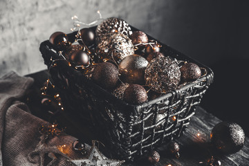 vintage christmas, new Year toys and decoration in basket on brown wooden table with garlands