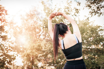 Beautiful woman doing stretching exercises on the floor.Young sportive woman doing exercising in summer park.