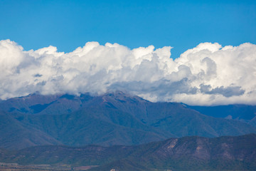 Fototapeta premium View of the peaks of the mountains in Kakheti and white clouds on blue sky.