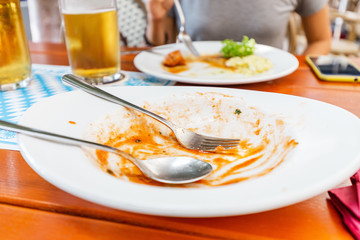 Dirty dishes on the table in the restaurant. The concept of gluttony and hunger and unhealthy diet