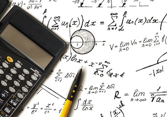 Closeup shot of complex math formulas on paper with calculator and ball pen aside.