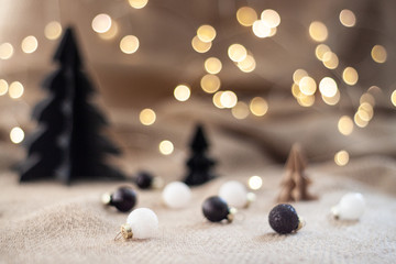 Close up glossy christmas balls with a paper christmas trees and and bokeh light as a background. Copy space