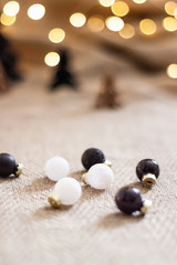 Close up glossy christmas balls with a paper christmas trees and and bokeh light as a background. Copy space