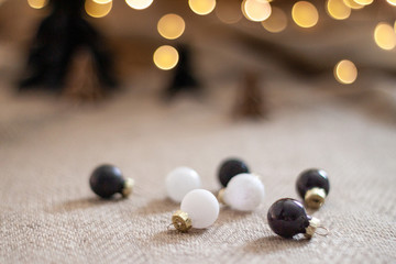 Close up glossy christmas balls with a paper christmas trees and and bokeh light as a background. Copy space