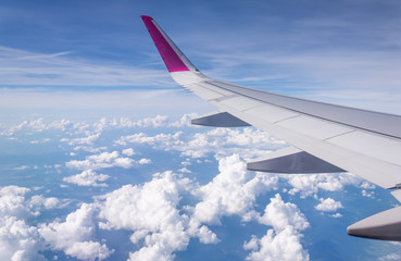 Fototapeta na wymiar wing of airplane flying above clouds