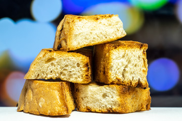 Homemade toasted white bread croutons. Close-up with a blurry color background.