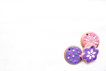 Icing gingerbread cookies on white wooden table, copy-space, space for text. Traditional Christmas homemade baking.