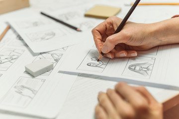 Hands draw a storyboard for the film.