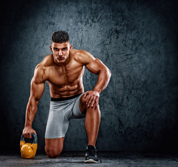 Fototapeta na wymiar Handsome Muscular Men Exercise With Kettlebell. Cross training athlete