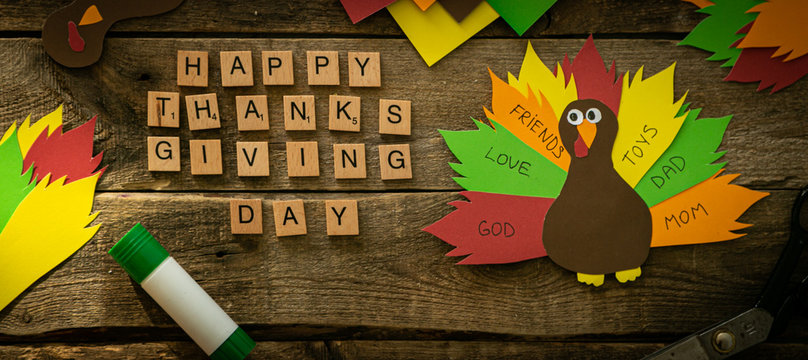 Thanksgiving paper craft - thanksful turkey on wood background, top view