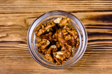 Cores of walnut in glass bowl on a wooden table. Top view