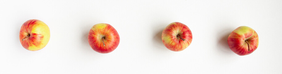 Banner flat lay top view of four red apples on white background. Food concept
