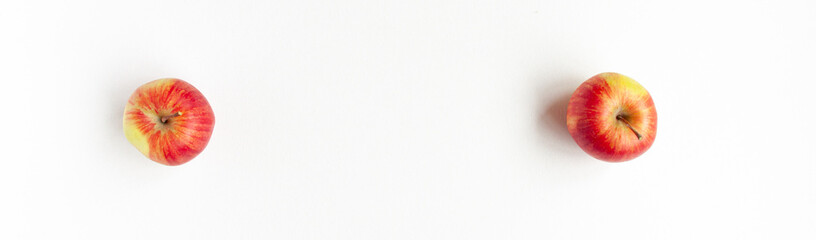 Banner flat lay top view of two red apples on white background. Food concept with space for text