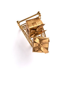 Shopping cart trolley basket gold color with gifts.