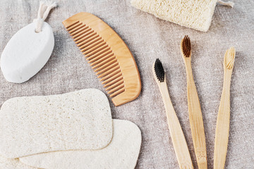 Natural set for bathing bamboo toothbrushes,  luffa spongle and wooden hairbrush on a linen...