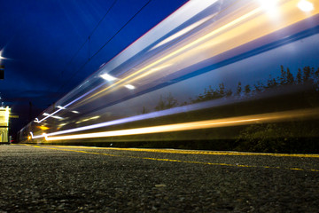 Fototapeta na wymiar Long exposure of passing trains in the night in a train station - Birmingham 