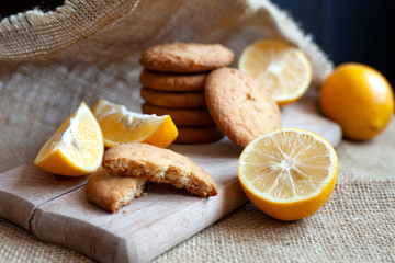 lemon gingerbread cookies lie on a wooden board on a rustic table, still life of fresh biscuits with citrus, copy space