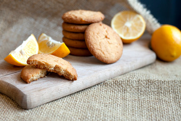 lemon gingerbread cookies lie on a wooden board on a rustic table, still life of fresh biscuits with citrus, copy space