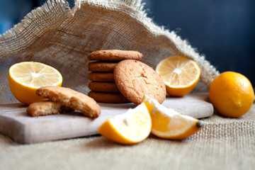 lemon gingerbread cookies lie on a wooden board on a rustic table, still life of fresh biscuits with citrus, copy space