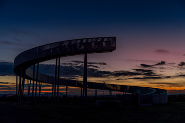Kobyli lookout point A wooden spiral construction in the South Moravia region during sunset with moving clouds and views of the exuberant farms and fields.