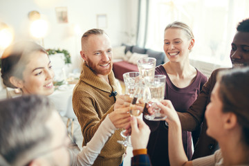 High angle view at group of elegant adult people clinking glasses during Christmas party in...
