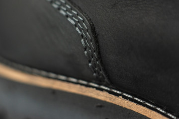 Naklejka premium vintage black boots on black background, detail of retro shoes