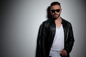 Attractive model looking forward and adjusting his shirt