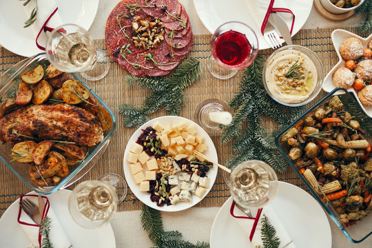 Top view background of rustic Christmas table with delicious homemade food decorated with fir branches, copy space
