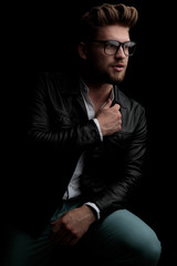 Fototapeta premium casual man wearing leather jacket sitting and looking aside