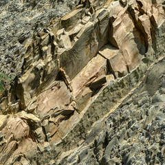 Striped natural texture of stones and rock fragments on Caucasus mountains on Black Sea coast in Olginka as original texture background. Brown, yellow, gray colored stone. Nature concept for design