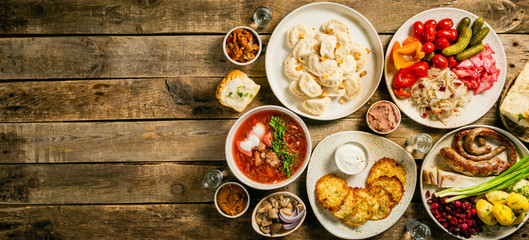 Selection of traditional ukrainian food - borsch, perogies, potato cakes, pickled vegetables, top view