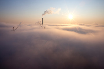 heavy fog over the city, purple sunny dawn over clouds, atmospheric smoke pollution concept
