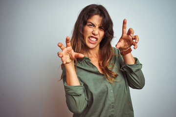 Young beautiful woman wearing green shirt standing over grey isolated background smiling funny...