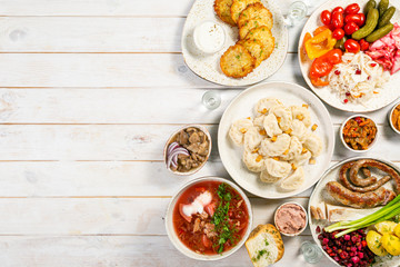 Selection of traditional ukrainian food - borsch, perogies, potato cakes, pickled vegetables, top view