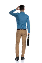 Fototapeta premium back view of confused young man scratching head