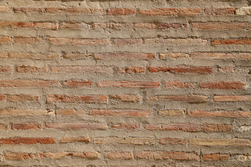 Textured background of thin red brick wall