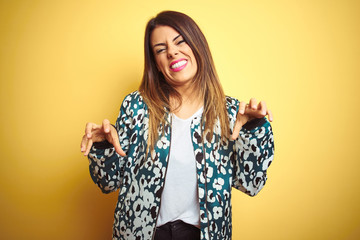 Young beautiful woman wearing casual jacket over yellow isolated background smiling funny doing...