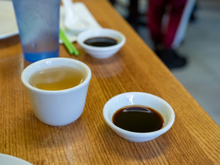 Glass of tea and small bowl of soy sauce on a restaurant table