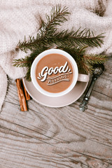 Hot coffee cup with cozy blanket on a wooden table with decorations