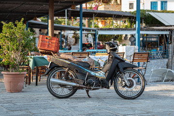 Fototapeta na wymiar Parked delivery motorbike with mounted orange basket.