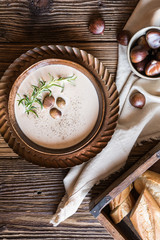 Obraz na płótnie Canvas Creamy chestnut soup with sour cream in a ceramic bowl